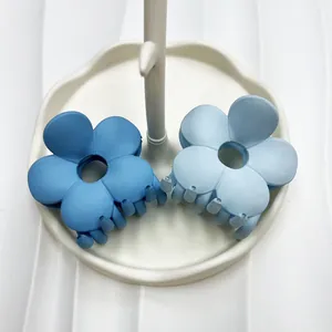 Dettaglio di fermagli per capelli a fiore opaco blu in un vassoio per gioielli