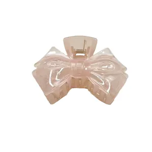 Translucent light pink bow hair claw clip with jellyfish texture and star detail