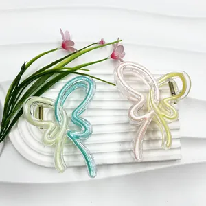 Chic butterfly shark hair clips in dopamine colors on a textured white pedestal base