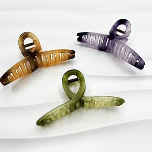 Close-up of 13cm matte hair claws in amber brown, lilac purple and moss green colors