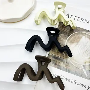 Set aus großen matten Wellen-Haarklammern in Creme, Schwarz und Kaffee auf Tablett