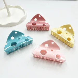 Set of four colorful cheese-shaped hair claws in pink, blue, yellow, and peach resin