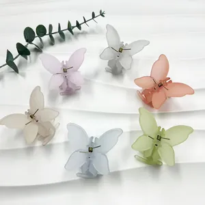 Détails de pinces à cheveux papillon mates en six tons pastel sur fond blanc texturé