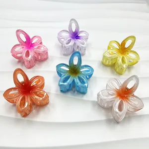 Detail of colorful hollow plumeria hair claws with gradient marble texture and matte finish