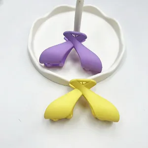 Detail of purple and yellow matte finish bow hair claws on a decorative white tray