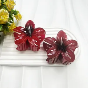 Makroaufnahme von glänzenden burgunderroten und violetten Haarklammern in Blumenform