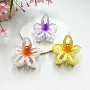 Close-up of hollow plumeria hair claws in gradient lavender, peach, and yellow colors