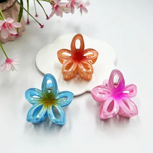 Close-up of hollow plumeria hair claws in gradient orange, blue, and purple colors
