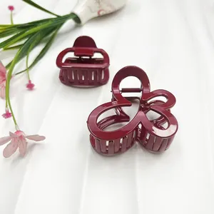 Eleganti mollette per capelli rosso intenso in forme rettangolari e floreali su sfondo bianco