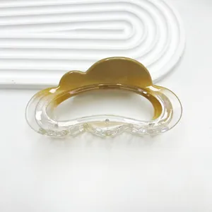 Macro shot of cloud-shaped amber gradient hair claw clip with elegant resin texture