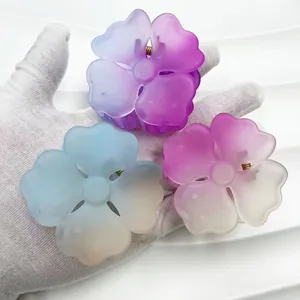 Macro shot of three matte flower hair claws in gradient pastel ice cream colors