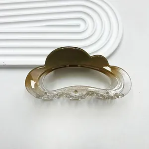 Close-up of cloud-shaped hair claw with amber gradient finish and silver glitter details
