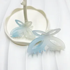 Dettaglio mollette per capelli a farfalla opache con sfumatura blu su vassoio