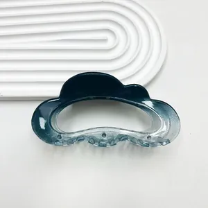Macro shot of cloud-shaped hair claw with blue gradient and shimmering glitter finish