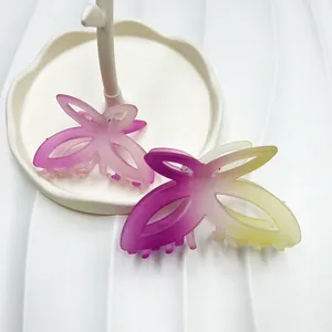 Dettaglio molletta per capelli a farfalla con texture sfumata opaca e design con intaglio