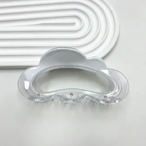 Detailed macro shot of a clear cloud-shaped hair claw clip with a sleek acrylic finish
