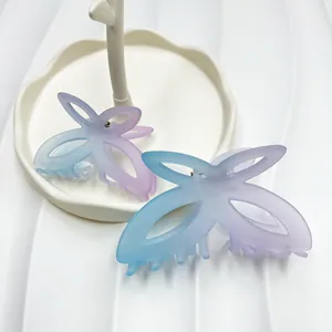 Primo piano di due mollette a farfalla opache con sfumatura blu e viola su un vassoio