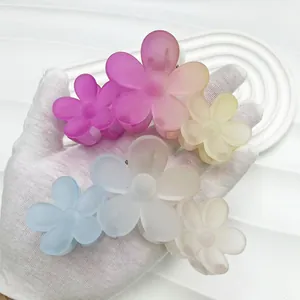 Detail of 11cm gradient flower hair claw clip in hand showing matte resin texture