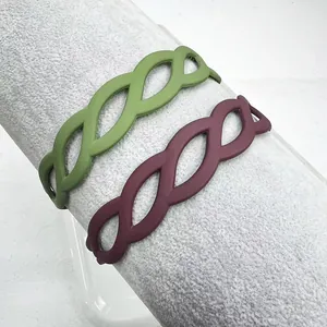 Close-up of matte green and burgundy hollowed-out leaf pattern headbands for women
