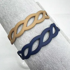 Close-up of matte braided hollow headbands in khaki and navy blue on a display stand
