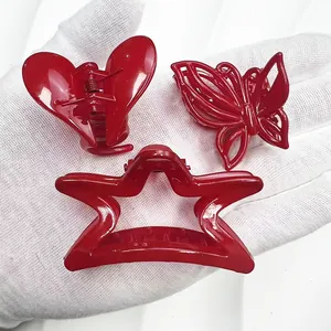 Vue macro de trois mini pinces à cheveux rouges en forme de cœur, papillon et étoile