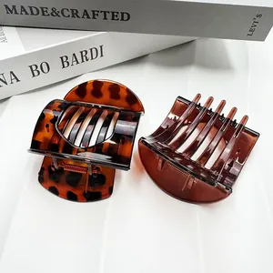 Close-up of tortoise shell resin hair clips with durable metal springs on a white surface