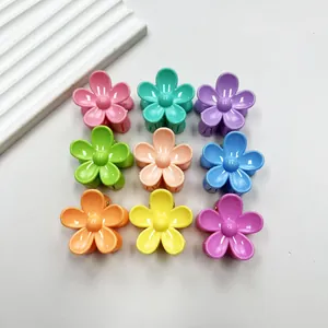 Flat lay of nine colorful 3cm flower hair clips in a variety of vibrant candy colors