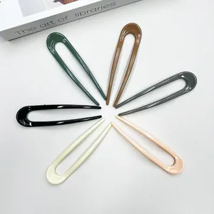Detailed macro view showing a set of six polished U-shaped hair pins in various colors