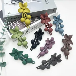Mollette per capelli a fiori opachi in nove colori disposte su una rivista