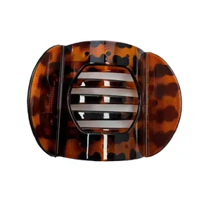Flat round tortoiseshell hair claw clip in dark brown resin for elegant hairstyles
