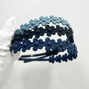 Dettaglio di tre cerchietti opachi a forma di margherita blu con dentini antiscivolo