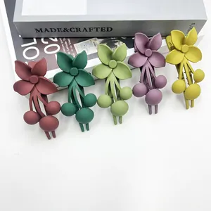 Dettaglio di grandi fermagli per capelli a fiore opaco in cinque diversi colori tenui