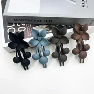 Dettaglio di quattro mollette per capelli a fiori opachi in nero, blu, grigio e marrone