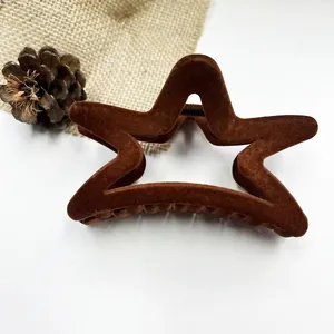 Detailed view of coffee brown velvet star hair claw clip with flocking texture and matte finish
