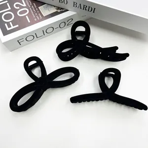 Set of three vintage black flocked bow hair claws for women on white background