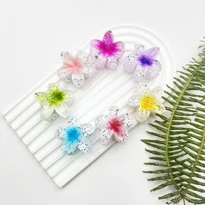 Dettaglio di sette fermagli per capelli a forma di fiore glitterati su base bianca