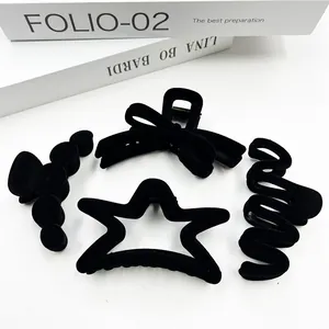 Detailed set of four black flocked hair claws including star and bow shapes on white background