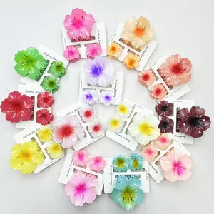 Set di mollette per capelli floreali opache in vari colori disposte su sfondo bianco