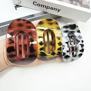 Trois barrettes en acétate aux motifs tortue, léopard et vache avec design ovale évidé