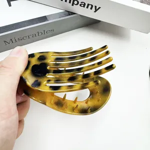 Détail d'une pince à cheveux motif léopard montrant la texture écaille et la prise