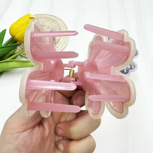 Détail de pince à cheveux fleur rose avec ressort doré et dents de fixation internes