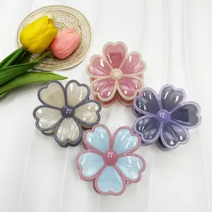 Détail de quatre pinces à cheveux florales en résine avec fini brillant et perle centrale