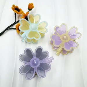 Detailed view of floral hair claws in pastel acrylic with beaded center textures