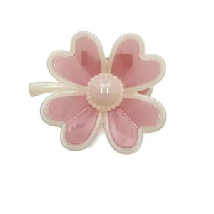 Pink and white clover hair claw clip with pearl accent on a clean white background