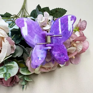 Close-up of double-layered purple marble butterfly hair claw clip with golden spring