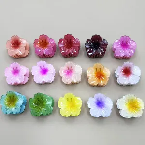 Vista piana di 15 mollette per capelli a fiore in vari colori sfumati per acconciature donna