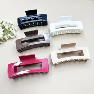 Flat lay of five assorted colors of soft silicone shark hair clips on a minimalist background