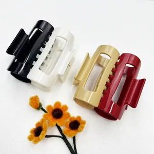 Detailed view of large rectangular hair claws in four colors on a white background