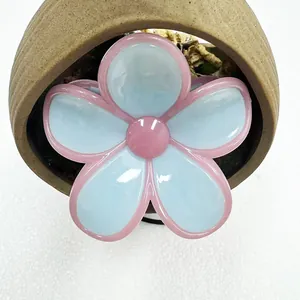 Close-up of a jelly texture five-petal frangipani hair claw in pink and blue finish