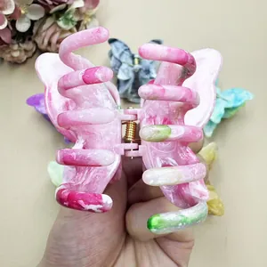 Detail of pink marble butterfly hair claw clip with strong gold metal spring mechanism
